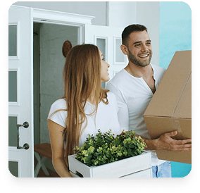 Happy couple moving into their new home with boxes and plants